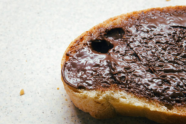 Chocolate cream on a slice of bread, macro view.