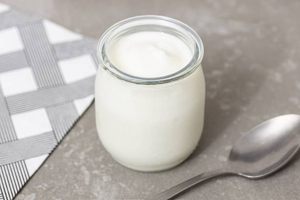 istock Yogurt Glass Jar on Table with spoon 2219702660
