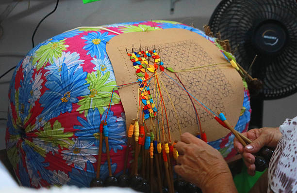 istock Bobbin (Bilro) lace production. Elderly woman's hands weaving exquisite lace. Traditional craftsmanship from Ceará. Bobbin lace in progress, an amazing textile art. Aquiraz, Ceará 2219704459