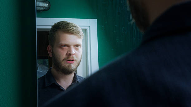 istock Bearded man stands indoors, facing a police officer with a serious expression, suggesting a tense or important conversation. 2219705017