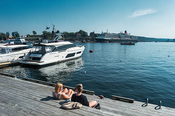 People relax on the waterfront in downtown Oslo, Norway on a sunny day.