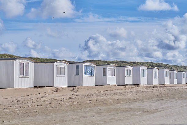 istock Charming Beachfront Row of White Beach Huts under a Bright Blue Sky 2219706662
