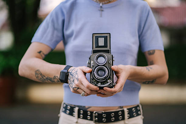 Young woman taking pictures with analog camera