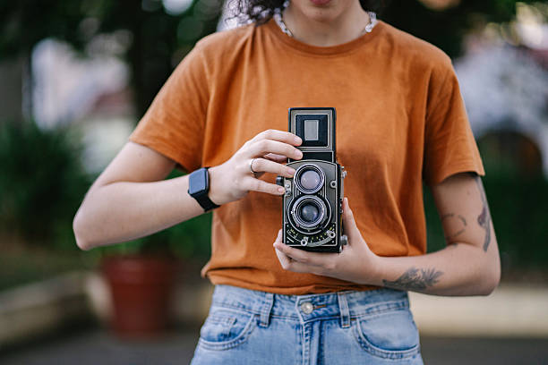 istock Young woman taking pictures with analog camera 2219713257