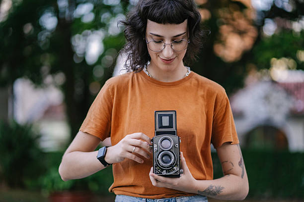 istock Young woman taking pictures with analog camera 2219713260