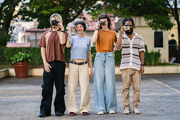Group of young friends interacting with old analog cameras