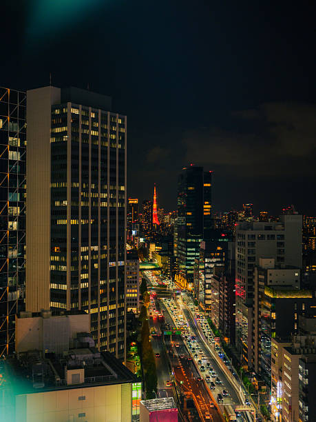 Tokyo tower  among skyscrapers illuminated at night, Japan