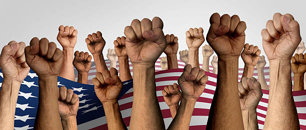 US Protest as American people protesting as upset angry protesters fists up in the air protesting as diverse community members in a social revolution or political protests crisis to change legislation and fighting for justice.