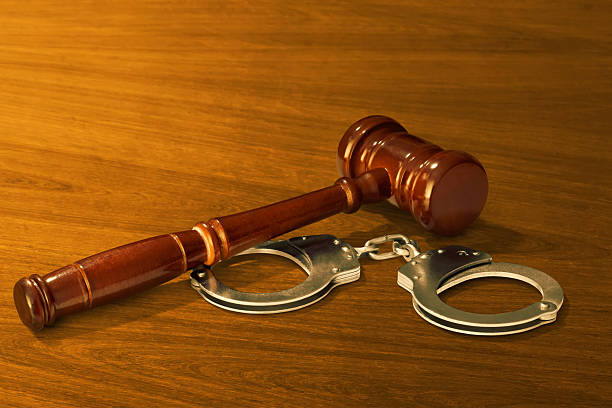 istock Handcuffs and judge gavel on wooden table 2219718987