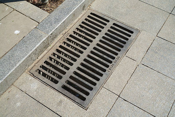 Drainage Grate On The Street With Stone Pavement Background