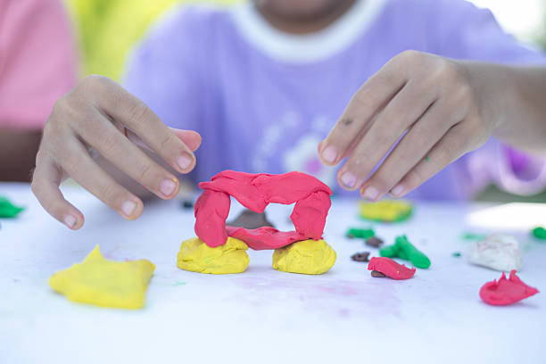 istock A child is playing with Play-Doh, creating a heart shape 2219733517