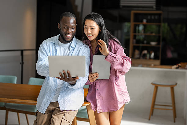 istock Remote work and digital business. Diverse couple collaborating online, managing projects with laptop 2219735335