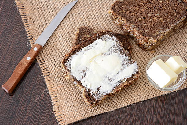Bread with butter and a knife on a sackcloth top view