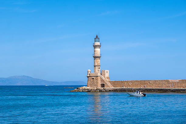Chania Crete. Lighthouse at old venetian harbour, blue sky and calm sea