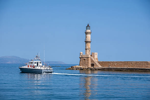 istock Chania Crete. A boat and lighthouse at old venetian harbour, blue sky 2219736103