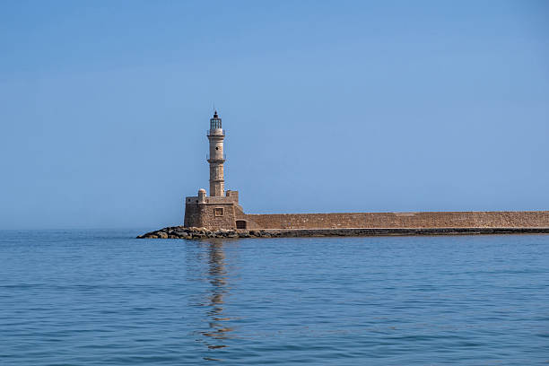 Chania Crete. Lighthouse at old venetian harbour, blue sky and calm sea