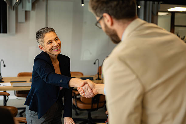 istock Two business people shaking hands in modern office 2219737203