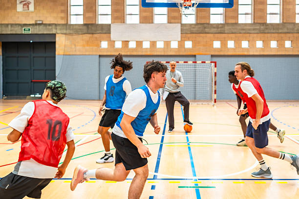 istock Basketball players running on court during training session with coach 2219738644