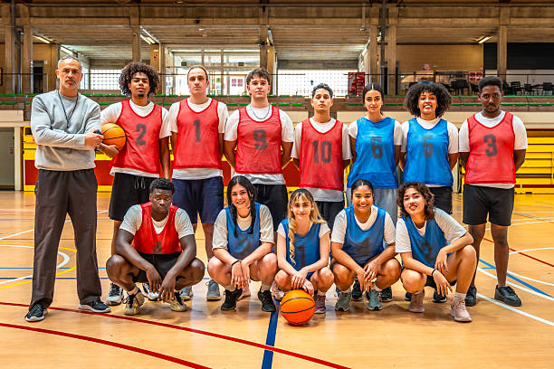 istock Basketball team posing with their coach in the gym 2219738737