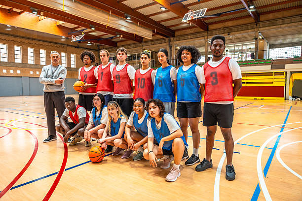 istock High school basketball team posing with their coach 2219738741