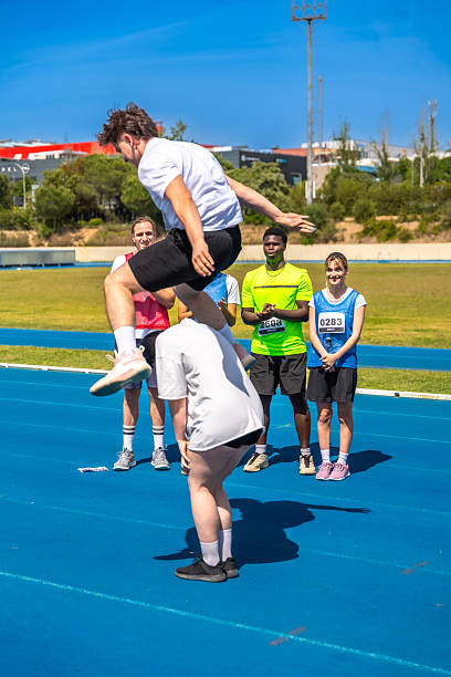 istock Young man leaping over another during track and field competition 2219738844