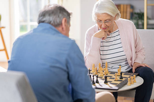 istock Senior Woman Strategizing Her Next Move in a Chess Game with Partner 2219742918