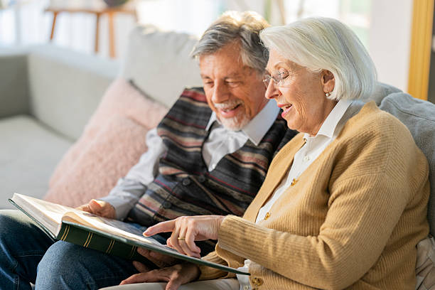 istock Joyful Elderly Couple Looking Through Old Photos 2219743372