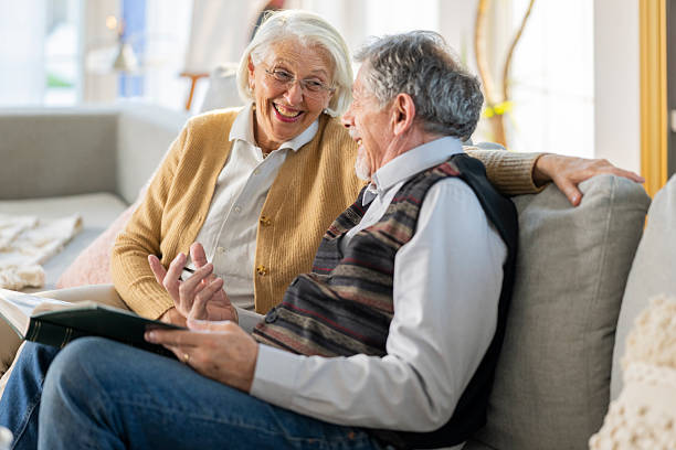 istock Joyful Elderly Couple Reminiscing on the Couch 2219743376
