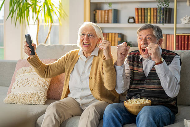 istock Senior Couple Cheering While Watching TV at Home 2219743422