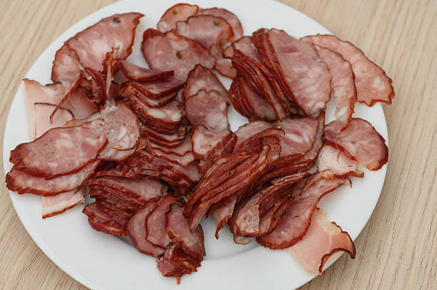 Smoked sausage cut into thin slices close-up on a plate