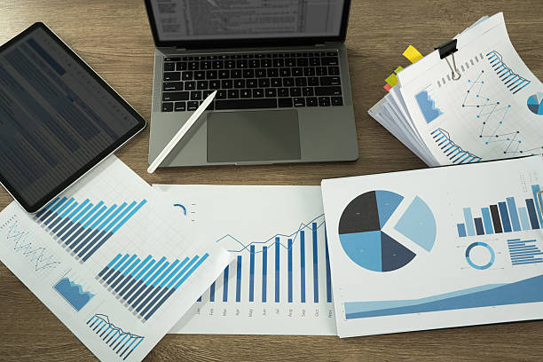 istock Report document image shows workspace with various financial charts, graphs, laptop, and tablet, indicating data analysis or business planning 2219751634