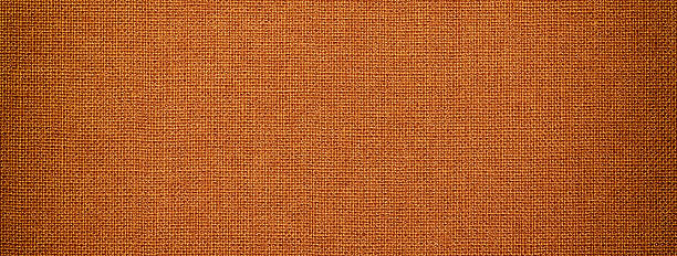istock Orange textile fabric background with rust woven texture and soft vignette in macro view for decorative design 2219753826