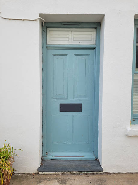 istock Modern, pale blue front door against a white stone wall 2219754560