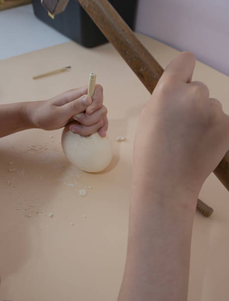 istock Hands Cracking a plaster dinosaur egg with a wooden mallet 2219754765