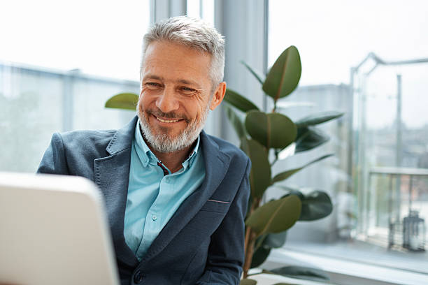 istock Smiling business professional working on a laptop in a modern office setting 2219757241