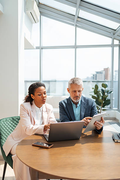 istock Two professionals collaborating in a modern office environment with natural lighting 2219757311