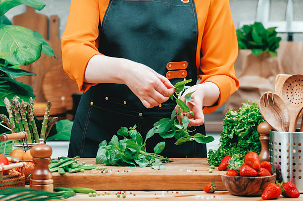 Freshly preparing organic vegetables and herbs in a vibrant kitchen by a culinary enthusiast during a sunny afternoon
