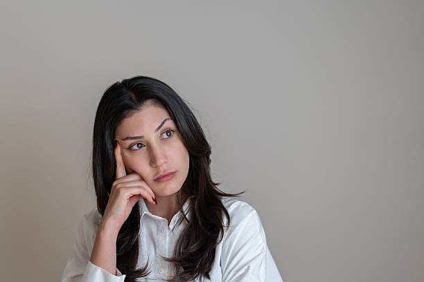 Young woman with a thinking face expression over white background