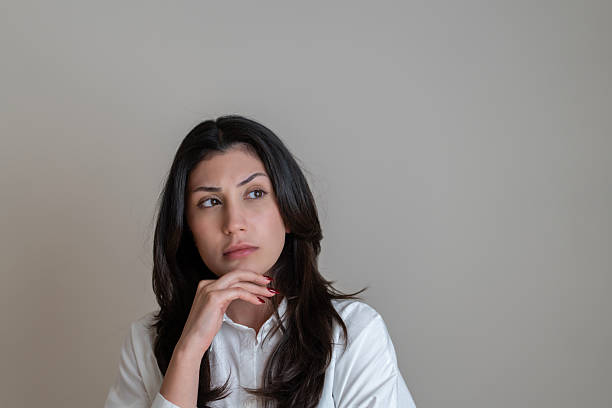 istock Young woman with a thinking face expression over white background 2219761143