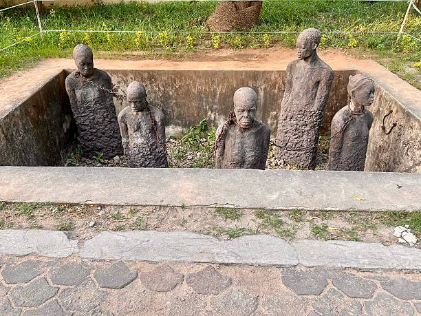 Five nude torsos of enslaved Africans emerge from stone pillars, whose rough and pebbled texture resemble the stones that fill the concrete pit that surround them.\n\nJanuary 4, 2025