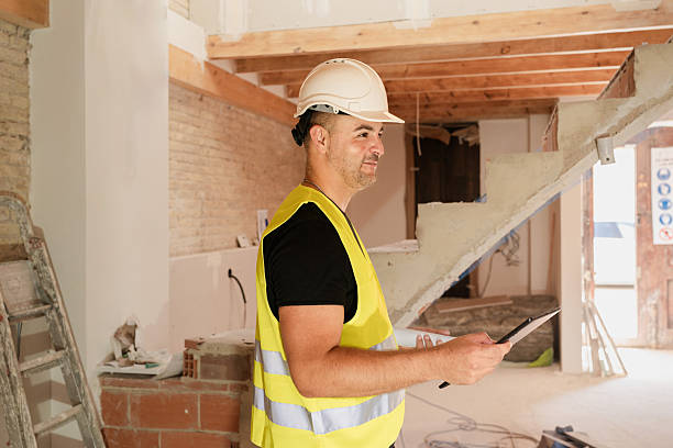 istock Male Supervisor checking building site using checklist on digital tablet during house renovation 2219763483