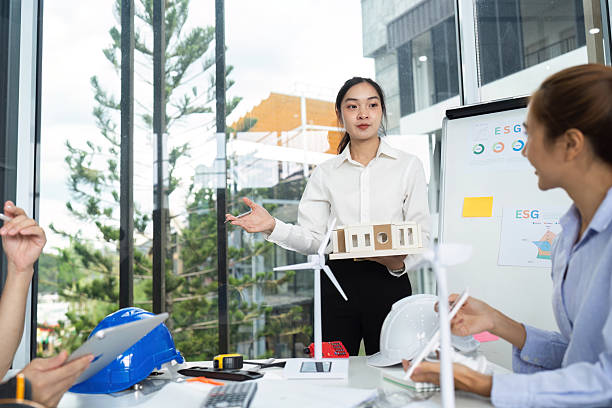 istock Sustainable Architecture Presentation. Female architect presenting eco-friendly model to team. 2219767899