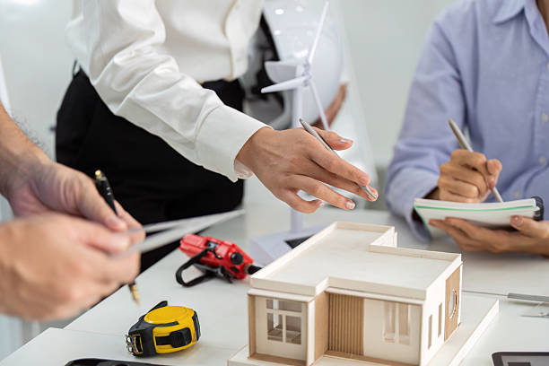 istock Sustainable Architecture Planning. Team discussing eco-friendly building design with model. 2219767953