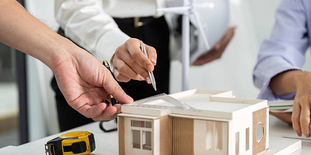 istock Sustainable Design Collaboration. Team reviewing architectural model for eco-friendly building. 2219767975