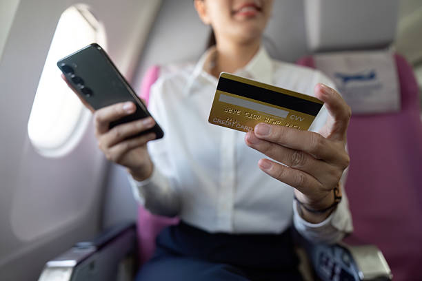 istock Payment Experience. Female traveler using credit card and smartphone on flight. 2219768464