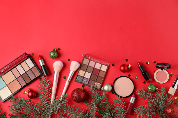 istock Flat lay composition with makeup products and Christmas decor on red background, space for text 2219768732