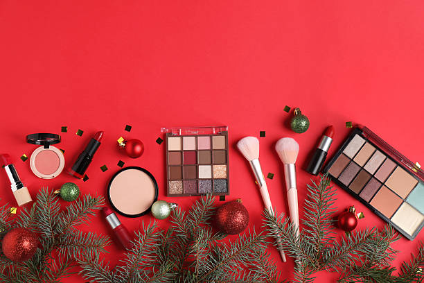 istock Flat lay composition with makeup products and Christmas decor on red background, space for text 2219768795