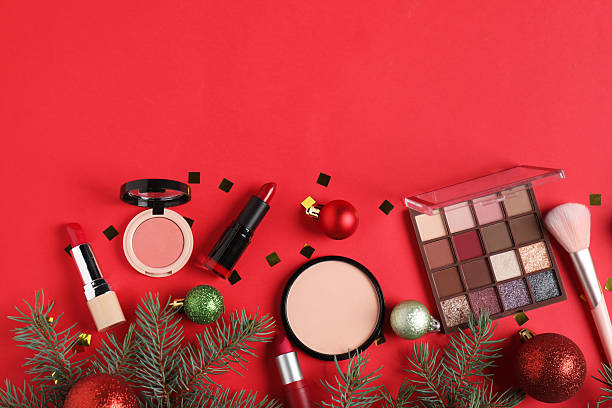 istock Flat lay composition with makeup products and Christmas decor on red background, space for text 2219768809