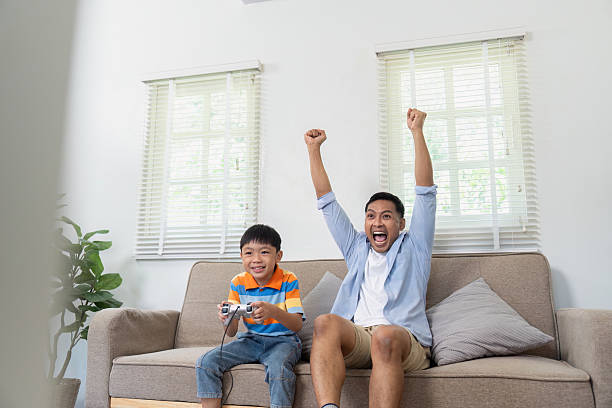 istock Excitement and Victory. Father and son celebrating while playing video games. 2219768829