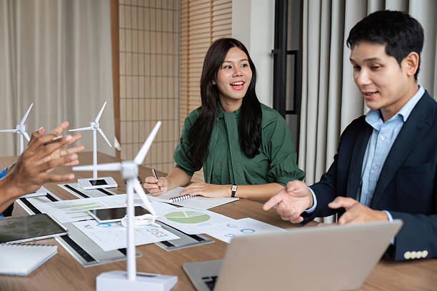 istock ESG Strategy Meeting. Professionals discussing renewable energy solutions with wind turbines. 2219769496